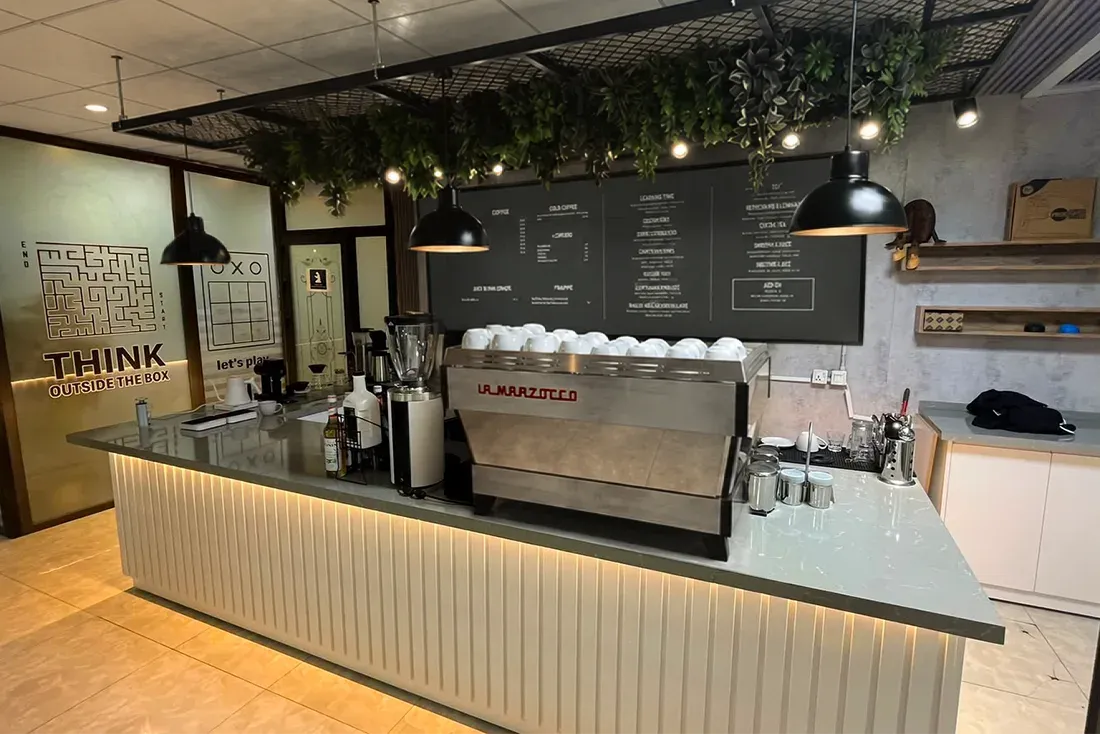 Photo of the finished Nava Brew bar with an espresso machine, menu board and hanging greenery